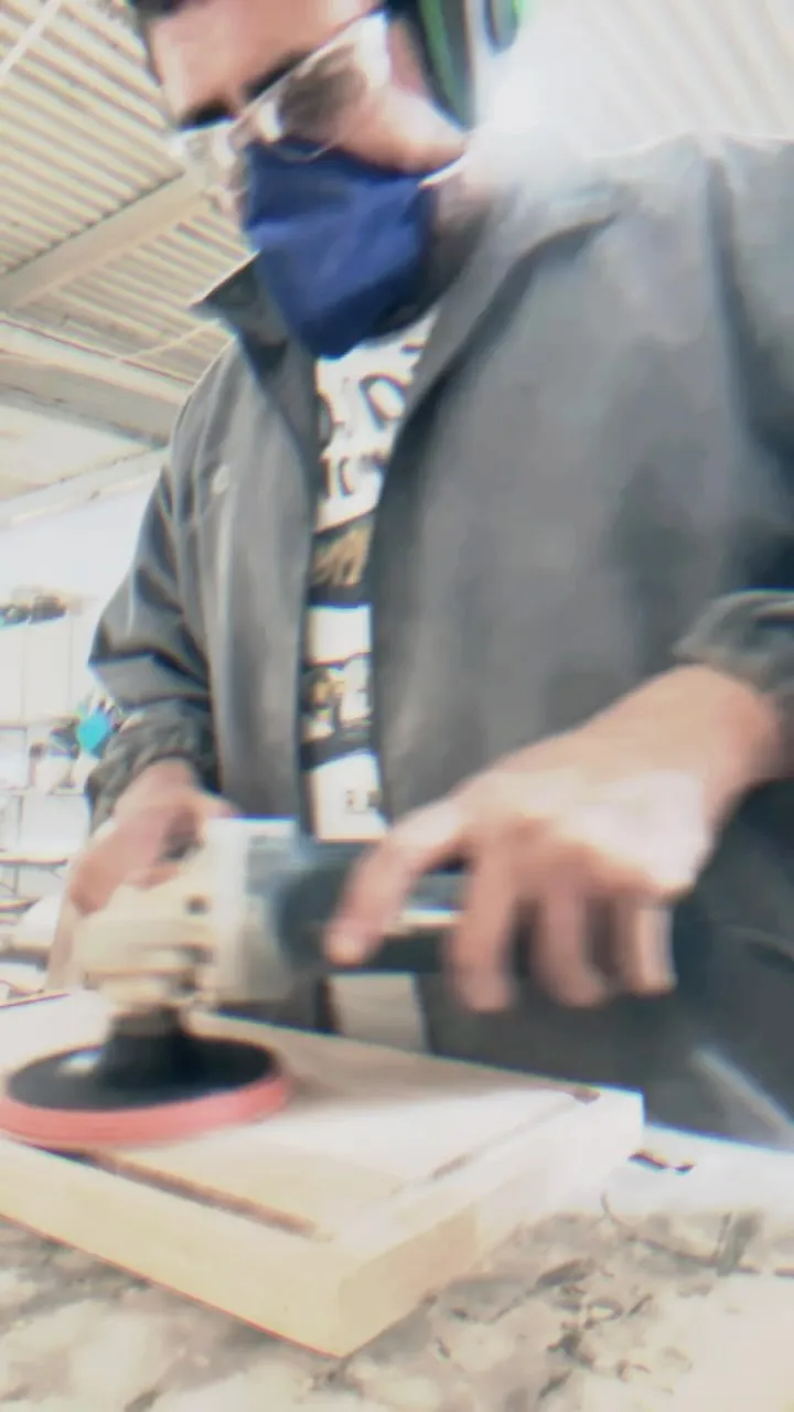 O dono da Wood King lixando uma tábua grande com a politriz
