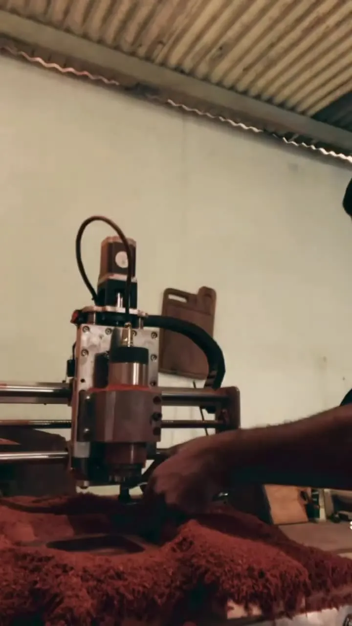 O dono da Wood King trabalhando na CNC no meio da serragem, o corte da madeira e a tábua AK pronta com resina preta