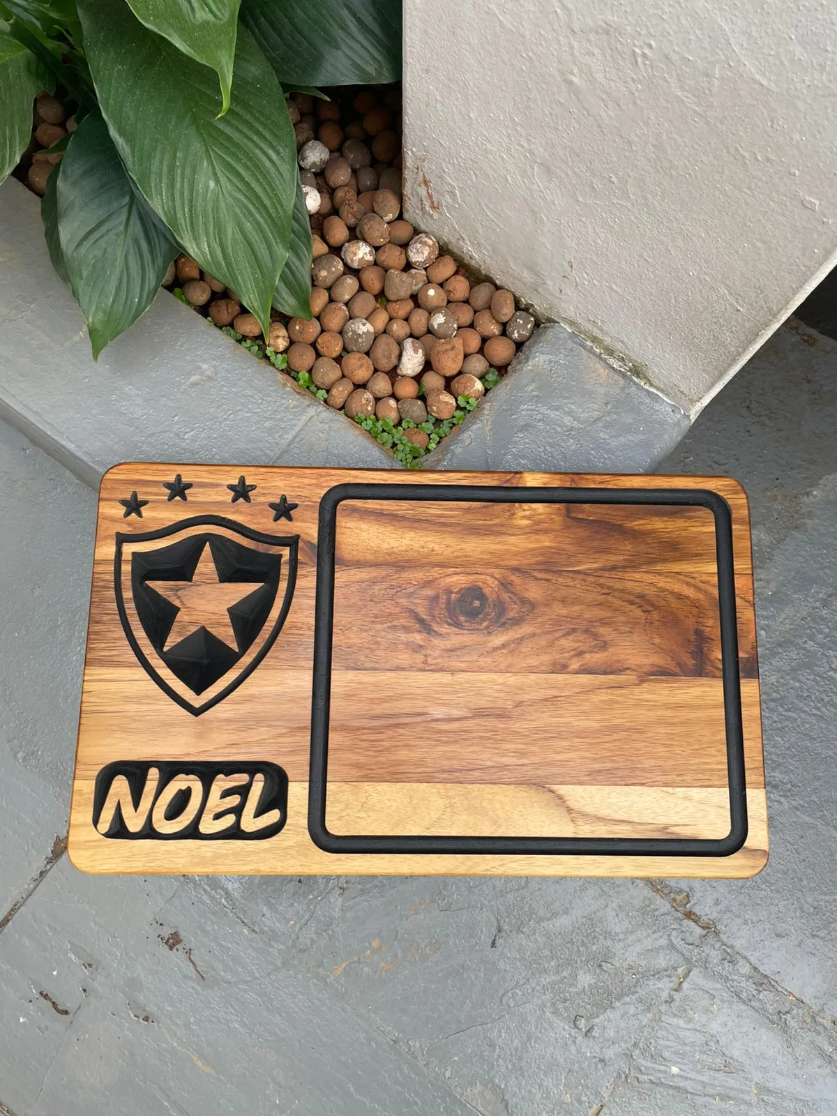 Tábua de teca com porta-molho e o escudo do Botafogo com o nome Noel em rebaixo